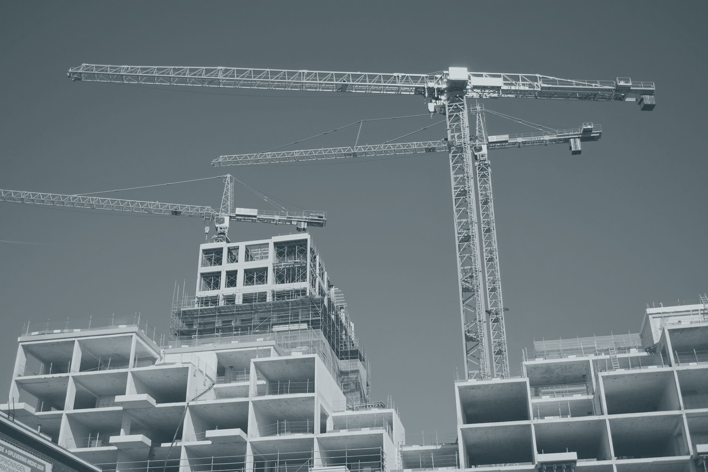 Tower cranes over a concrete-frame building under construction
