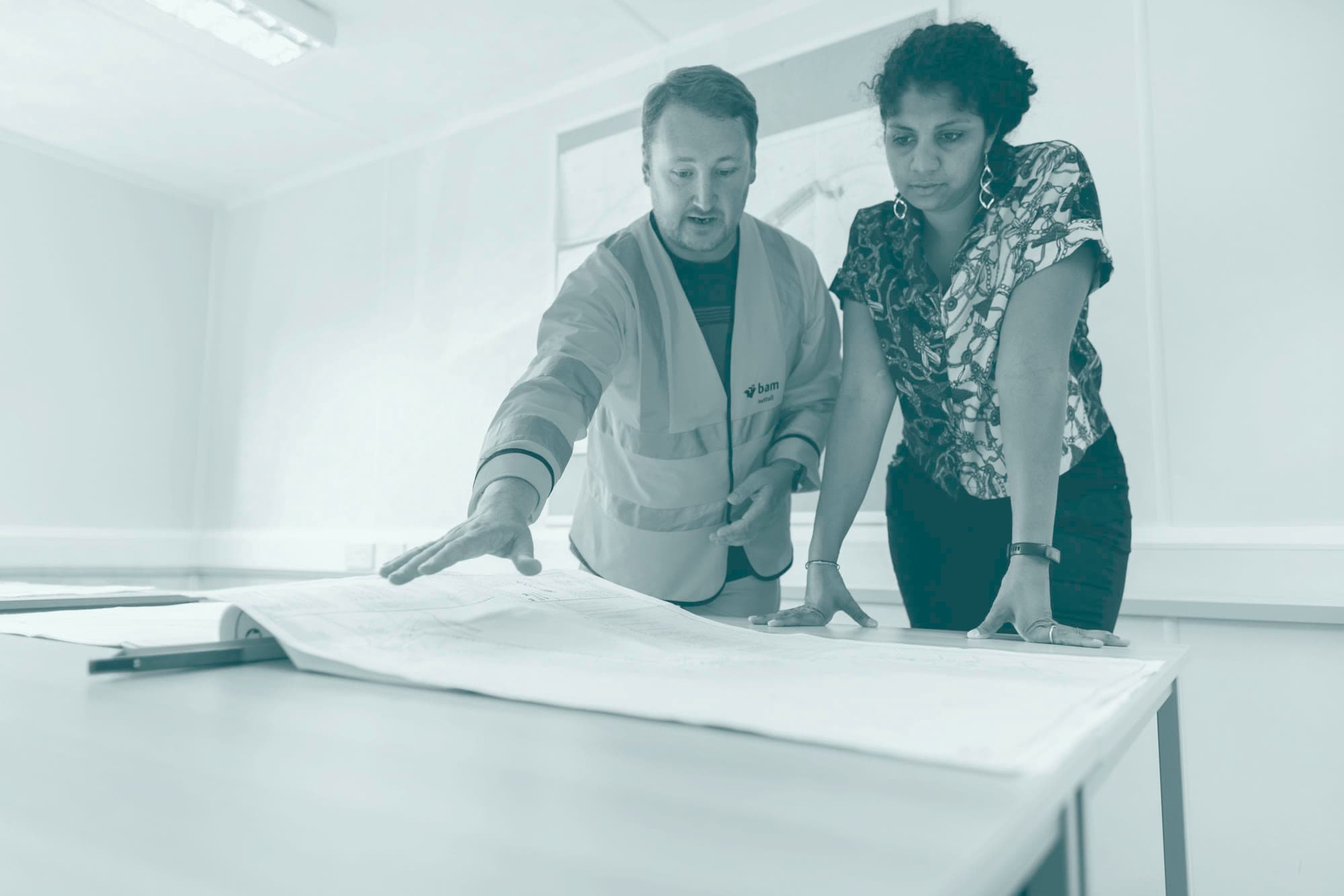 Two people reviewing construction drawings together