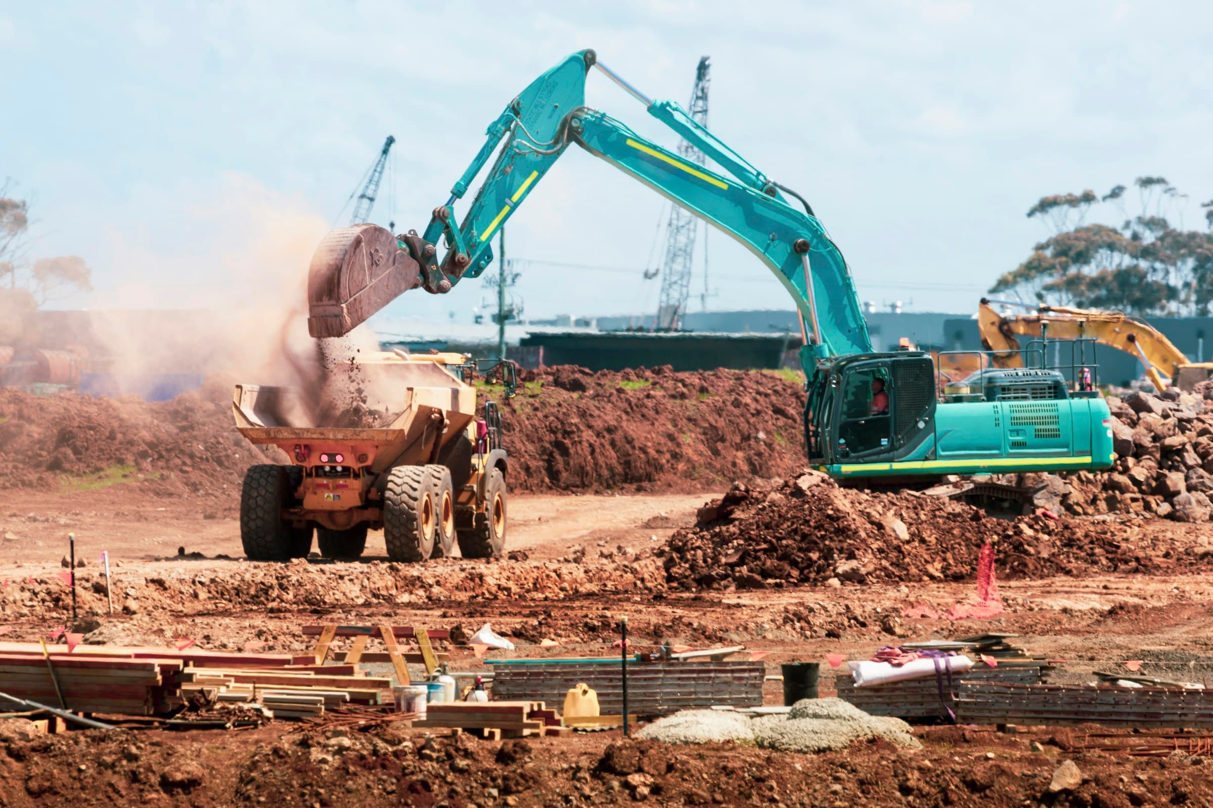 Excavator grading earth on a construction site