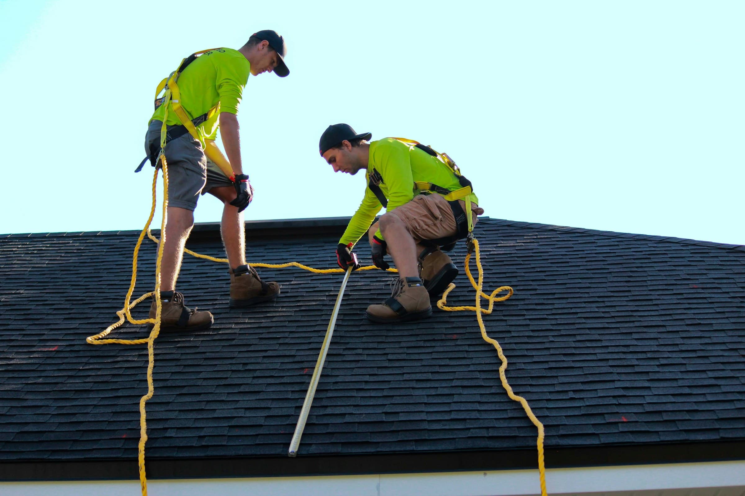 Roofers installing shingles on a pitched roof